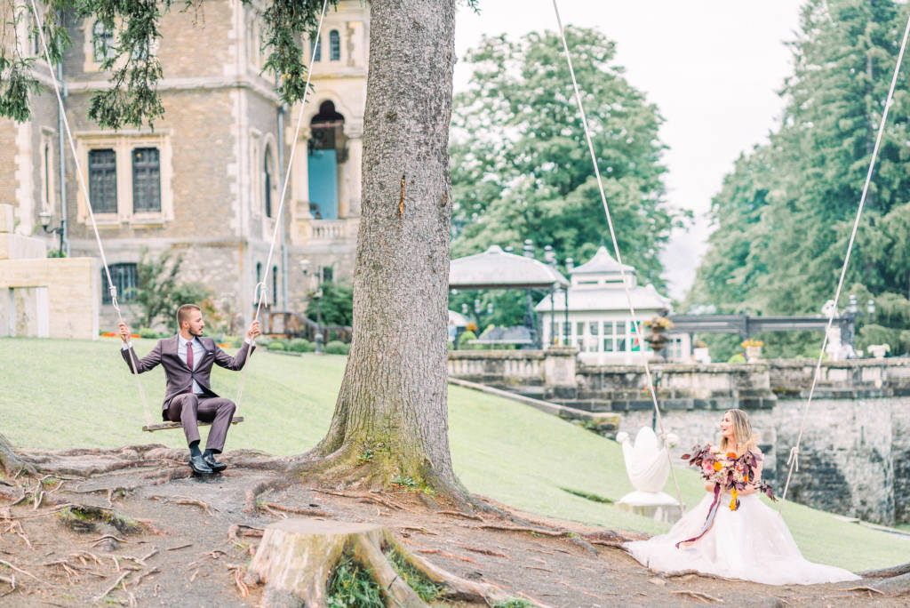 Bride and groom on swings at Cantacuzino Castle, Romania